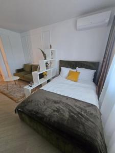 a bedroom with a large bed and a couch at Happy Studio Cortina de Luxe in Voluntari