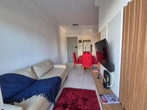 a living room with a couch and a red table at 205 Vista do atlântico in Serra