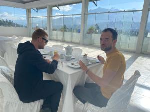 two men sitting at a table eating food at Los ROYALS Hotel Huaraz in San Antonio
