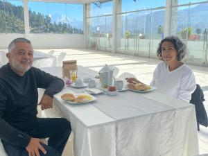 a man and a woman sitting at a table with food at Los ROYALS Hotel Huaraz in San Antonio