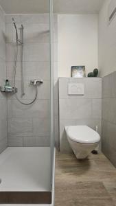 a bathroom with a shower and a toilet and a sink at Ferienwohnung GreenLook - Ferien am Lungernsee in Bürglen
