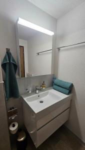 a bathroom with a white sink and a mirror at Ferienwohnung GreenLook - Ferien am Lungernsee in Bürglen