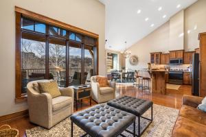 Una sala de estar con un sofá y sillas y una cocina. en Penthouse 7 on Taneycomo - Chic Waterfront Condo, en Branson