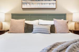 Un dormitorio con una cama grande con almohadas. en Penthouse 7 on Taneycomo - Chic Waterfront Condo, en Branson