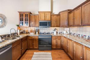 Una cocina con gabinetes de madera y un horno de estufa. en Penthouse 7 on Taneycomo - Chic Waterfront Condo, en Branson
