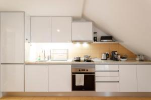 a kitchen with white cabinets and a black oven at Suite in Cozy Apartment in Chiado in Shared House in Lisbon