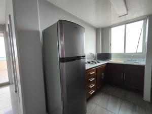 a stainless steel refrigerator in a kitchen with a window at La colina in San Roque