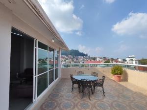 a patio with a table and chairs on a balcony at La colina in San Roque
