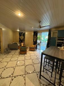 a living room with a table and a tiled floor at Les Tainas in Faaa +21 photos