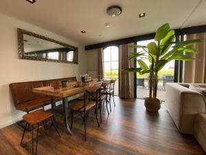 a dining room with a table and chairs and a mirror at De Kolibrie in Garderen