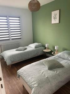 a bedroom with two beds and two lamps on tables at Maison Mara in Montliot-et-Courcelles