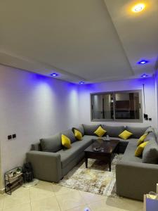 a living room with a gray couch and yellow pillows at Apparemment Al Hoceïma in Al Hoceïma +3 photos
