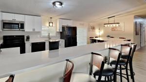 a kitchen with a bar with chairs and a counter top at Put-in-Bay Island Club #4 in Put-in-Bay +29 photos