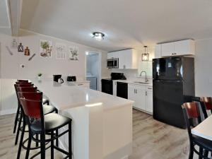 a kitchen with white cabinets and a black refrigerator at Put-in-Bay Island Club #4 in Put-in-Bay