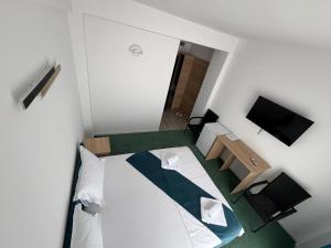 a small white room with a bed and a television at Sunrise Boutique in Costinesti +60 photos