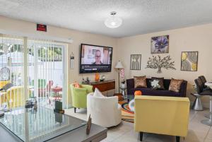 プランテーションにあるAmazing Home Just Mins To Hospitals Golf & Parksのソファとテレビのあるリビングルーム