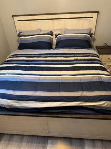 a bed with a blue and white striped comforter at Classic king and queen suite in Schenectady