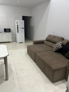 ein Wohnzimmer mit einem braunen Sofa und einem Kühlschrank in der Unterkunft Casa in Trindade