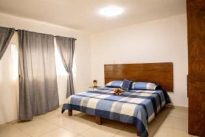 ein Schlafzimmer mit einem Bett mit einer blau-weißen Decke in der Unterkunft Centro Queretaro Hospedaje Castillo in Casa Blanca La Corregidora