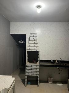 ein Zimmer mit einem Fernseher in einer Ziegelwand in der Unterkunft Casa in Trindade