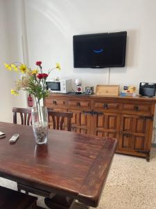 a table with a vase of flowers on top of a tv at Casa cozy e luminosa - Tiburtina in Rome