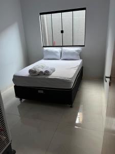 ein Bett mit zwei Handtüchern auf einem Zimmer in der Unterkunft Casa in Trindade