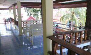 a porch with benches and tables in a building at Rimtalay Resort Koh Si Chang in Ko Si Chang