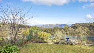 a yard with a view of the water and trees at Stunning Cliff Face and Valley Views in Katoomba