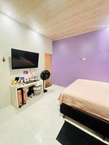 a bedroom with a bed and a flat screen tv at Casa cidade nova in Ananindeua