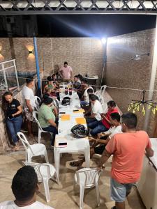 a group of people sitting around a long table at Casa cidade nova in Ananindeua