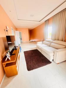 a living room with a white couch and a television at Casa cidade nova in Ananindeua