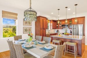 a dining room with a table and chairs in a kitchen at Pili Mai 8K in Koloa