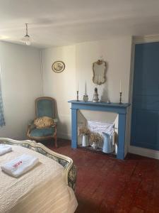 a bedroom with a bed and a blue fireplace at Maison Belle Croix in Châtillon-Coligny