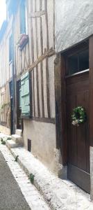 a building with a wooden door on a street at Maison Belle Croix in Châtillon-Coligny