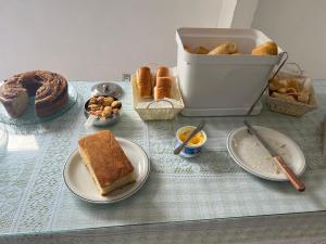 a table topped with plates of bread and pastries at Pousada do Genesio in Petrópolis