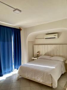 a bedroom with a large bed with blue curtains at Casa Blanca in Santa Cruz Huatulco