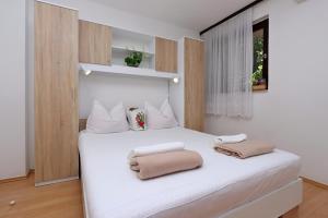 a bedroom with a white bed with two pillows on it at Apartments with parking space Selce, Crikvenica - 24450 in Selce