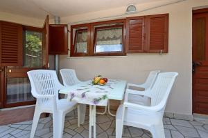 a white table with white chairs and fruit on it at Apartments with parking space Selce, Crikvenica - 24450 in Selce