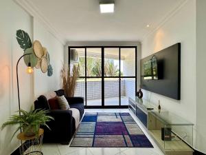 a living room with a couch and a tv at (103) Beach Garden na praia da litorânea in Pimenta