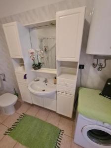 a white bathroom with a sink and a toilet at Family-friendly apartments with swimming pools Opatija - Pobri, Opatija - 24607 in Matulji