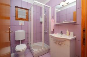 une salle de bains rose avec toilettes et lavabo. dans l'établissement Seaside holiday house Prizba, Korcula - 24637, à Blato 17 autres photos