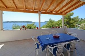 une table et des chaises sur un balcon avec vue sur l'eau dans l'établissement Seaside holiday house Prizba, Korcula - 24637, à Blato