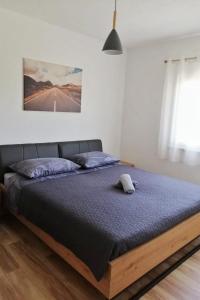 a bedroom with a bed with a blue bedspread at Apartments with swimming pool Bacici, Krka - 24721 in Drinovci