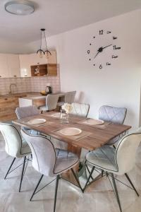 a dining room table with chairs and a clock on the wall at Apartments with swimming pool Bacici, Krka - 24721 in Drinovci