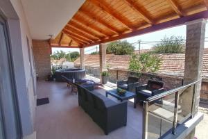 a patio with couches and a grill at Apartments with swimming pool Bacici, Krka - 24721 in Drinovci