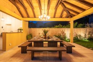 a patio with a wooden table and a chandelier at Villa MarLea in Dubrovnik +40 photos