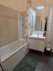 a bathroom with a white tub and a sink and a bath tub at Appartement chaleureux de 2 chambres in Courcouronnes