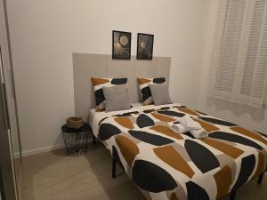 a bedroom with a large bed with a black and white comforter at Appartement chaleureux de 2 chambres in Courcouronnes