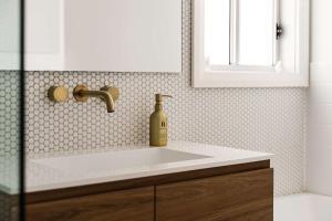 a bathroom sink with a bottle of soap on it at Highview Escape in Mount Victoria