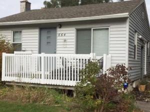 ein Haus mit einem weißen Zaun davor in der Unterkunft Corporate insurance or family vacation in Wolverine lake in Walled Lake